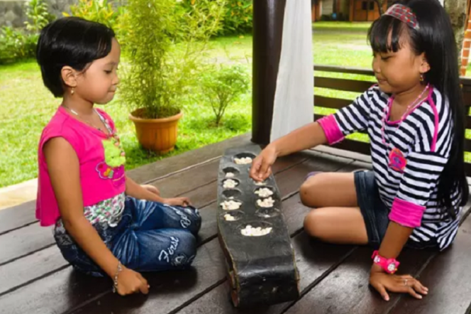  Congklak, salah-satu permainan tradisional anak Indonesia. (Sumber foto: m.kaskus.co.id).*
